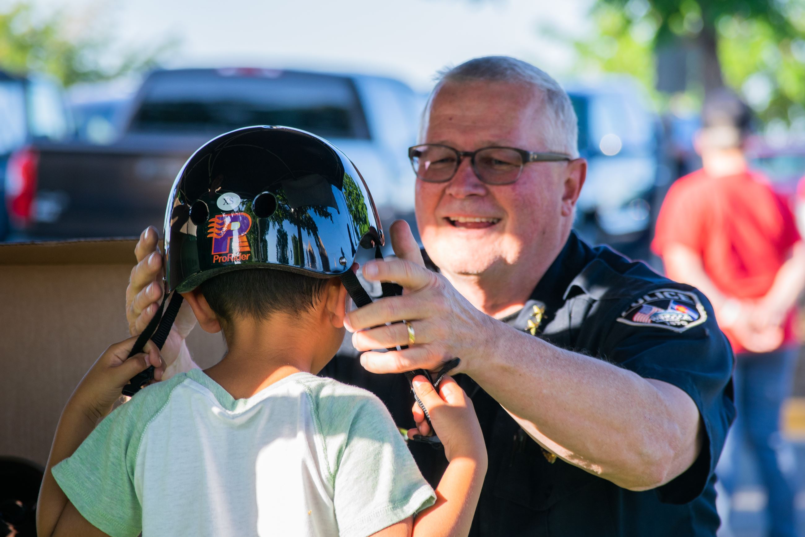 Chief Klimek fitting a child with a bike helmet